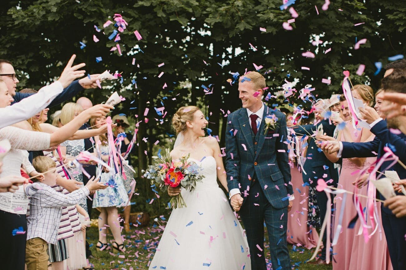 bride and groom walking through confetti