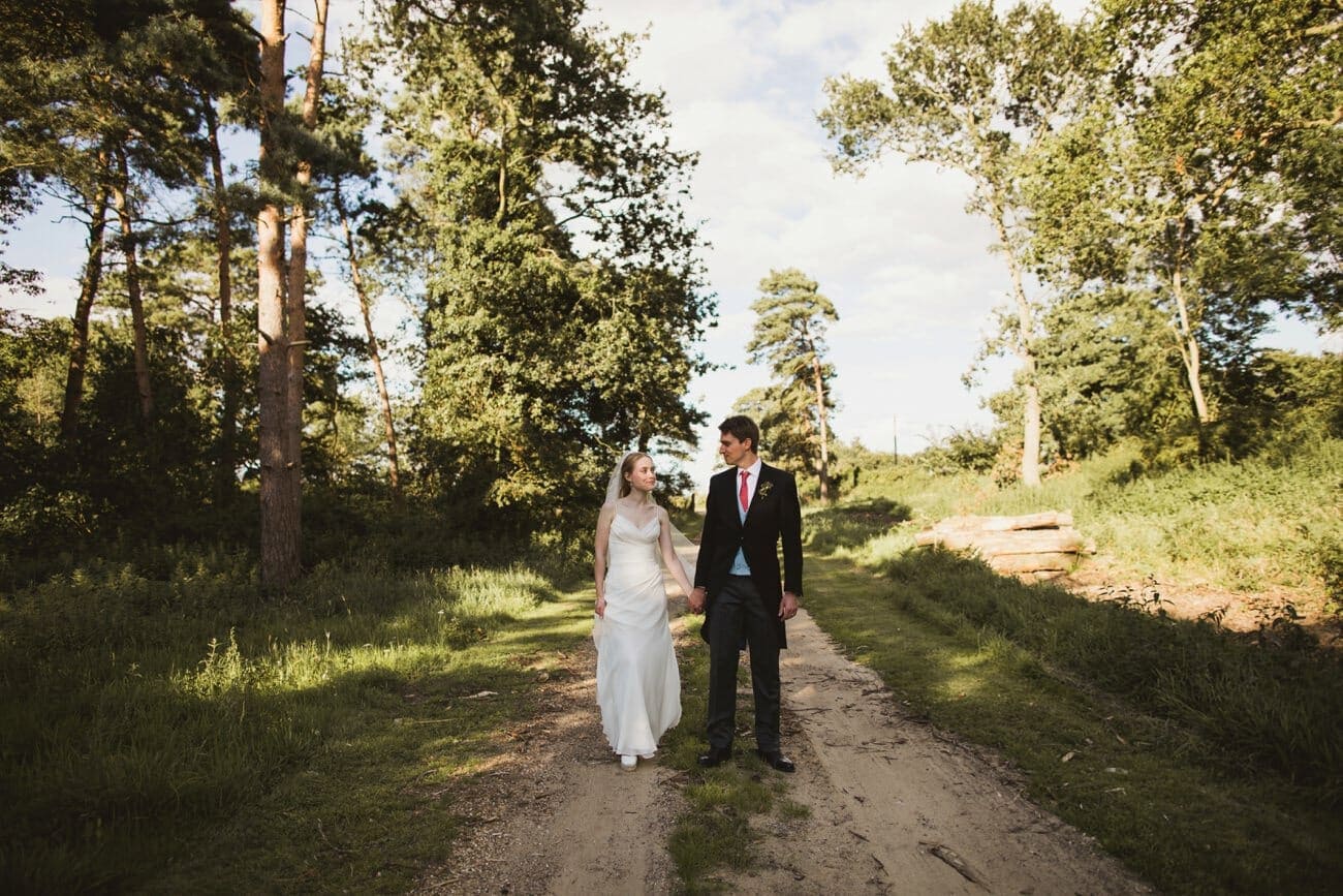 bride and groom walking through the grounds at butley priory