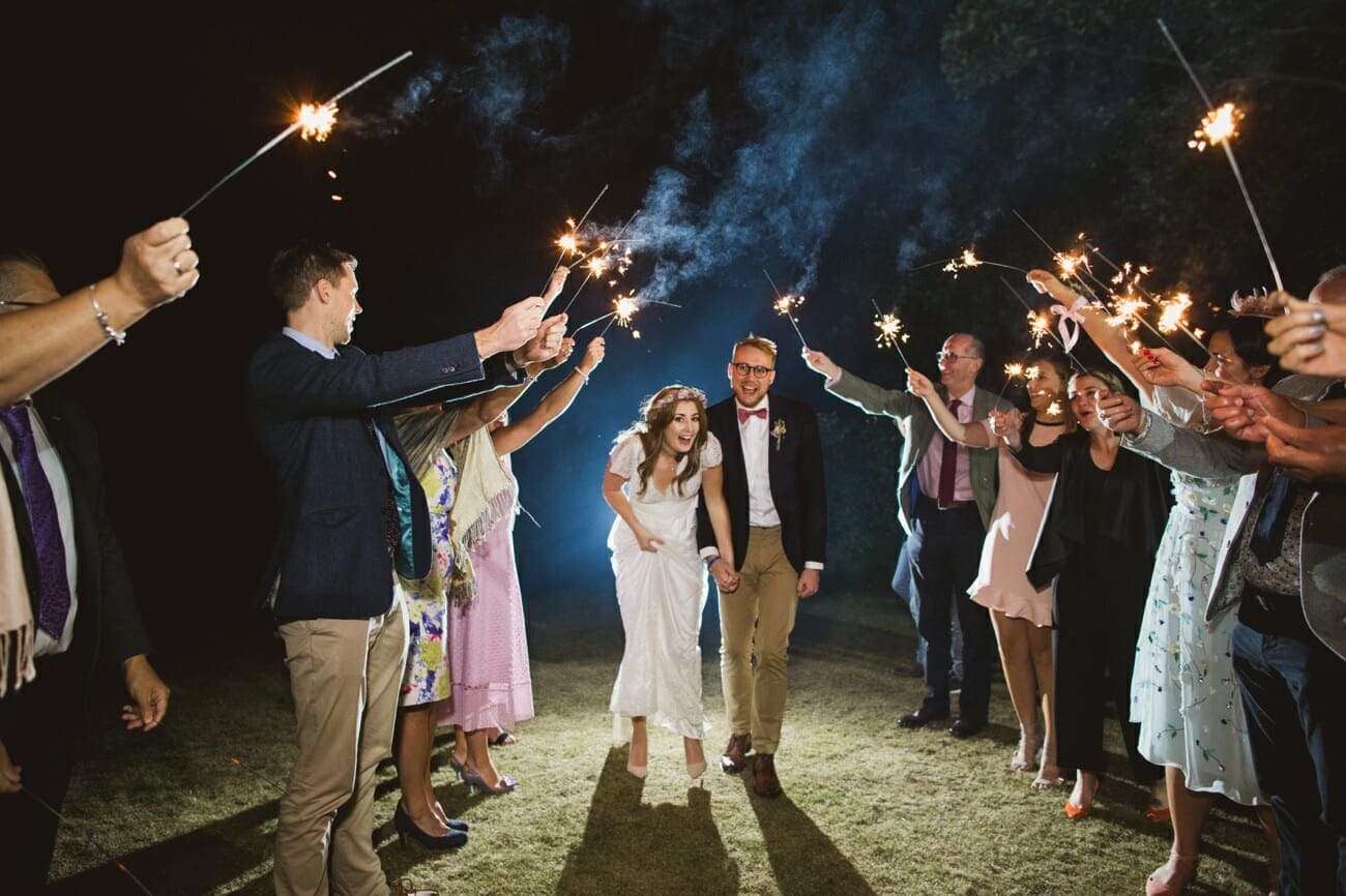 bride and groom walking through sparklers at suffolk wedding