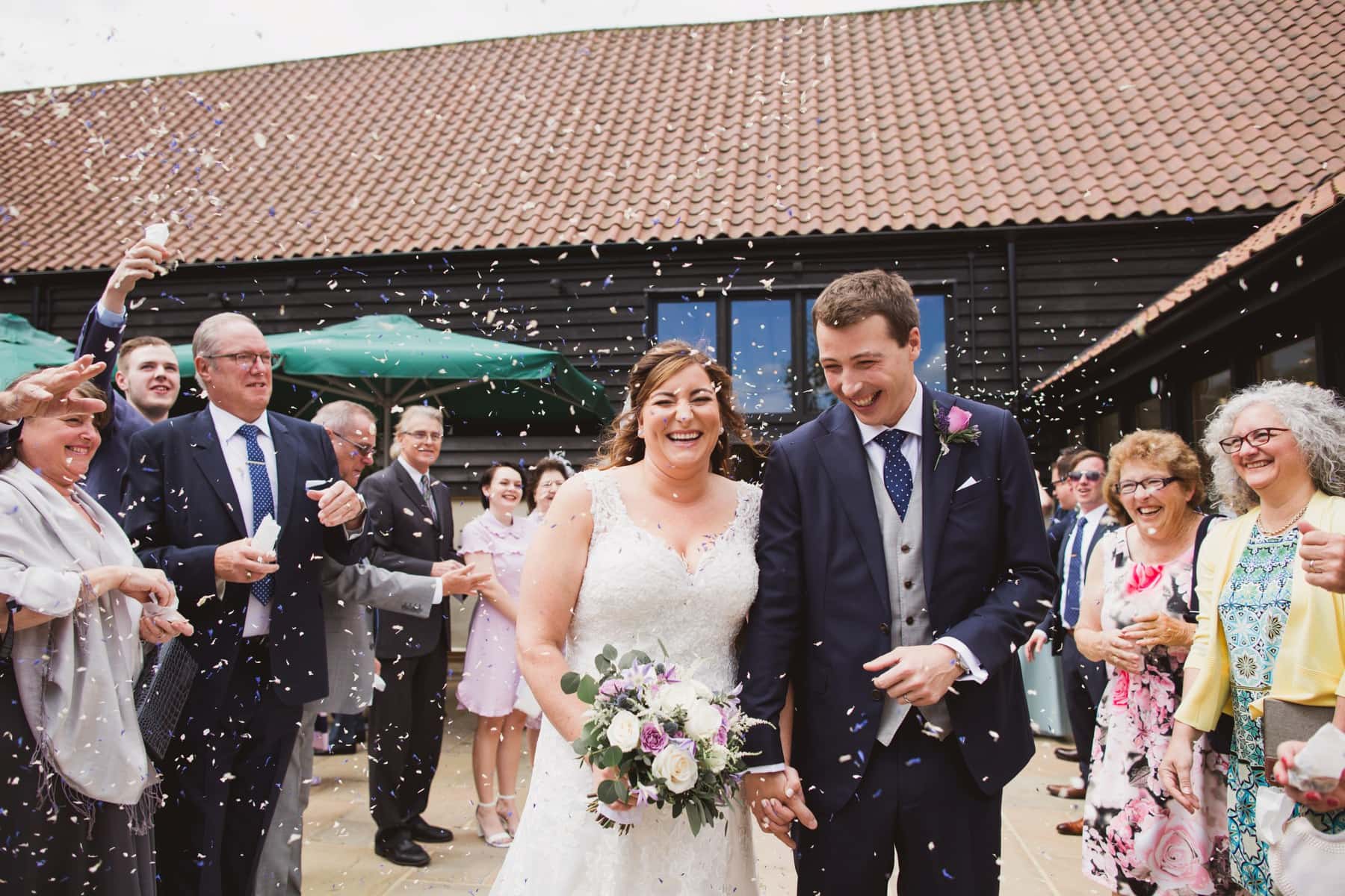 bruisyard hall and barn wedding bride and groom leaving with confetti