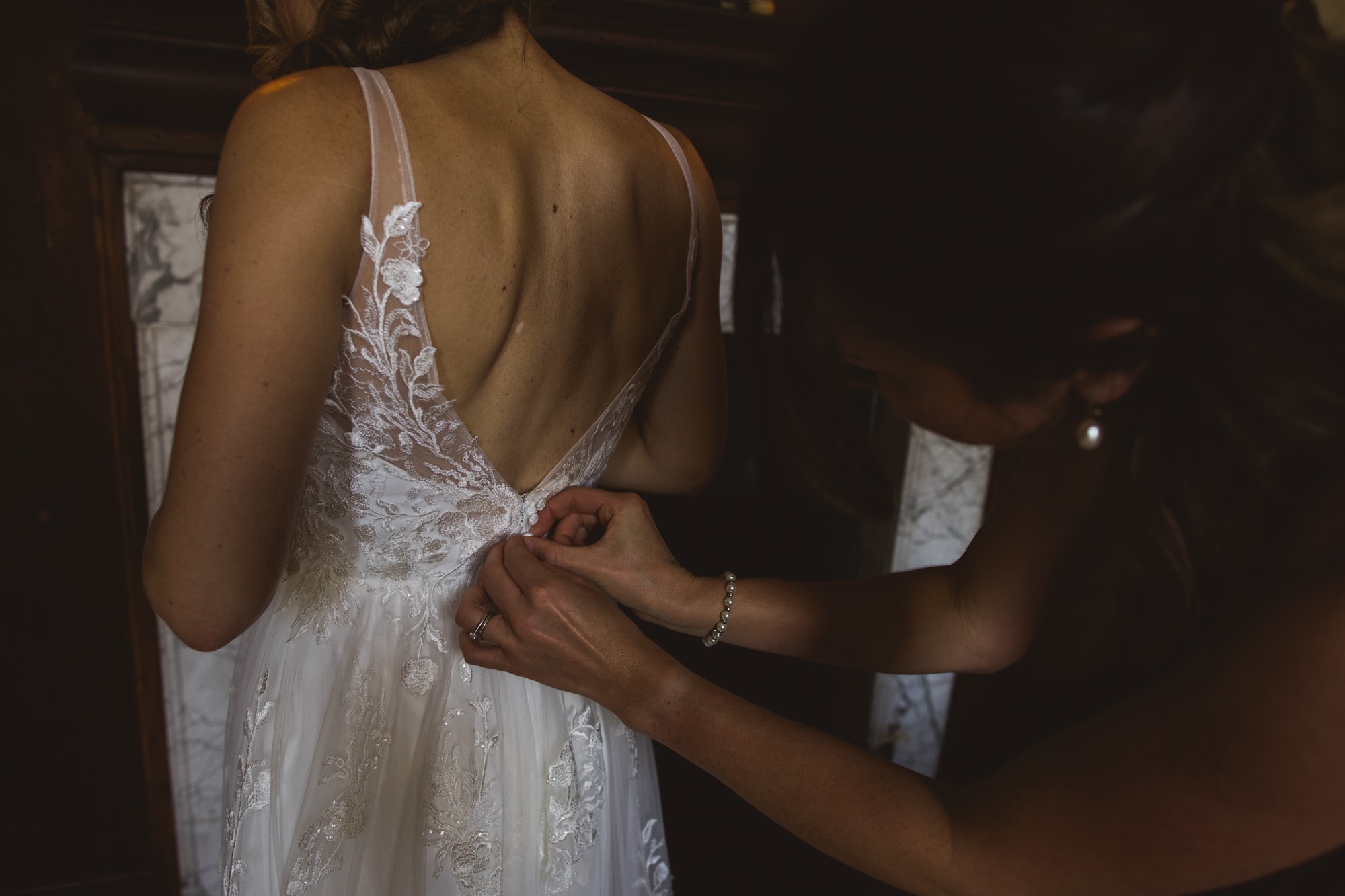 brides dress being buttoned up