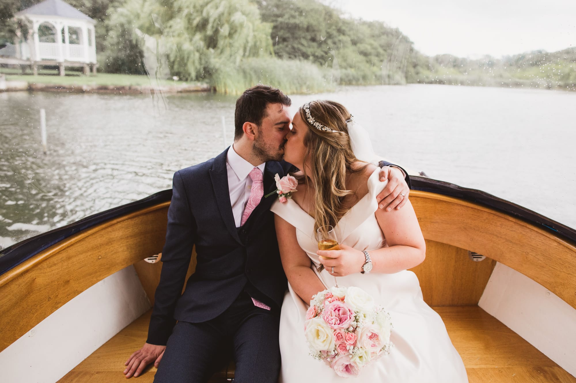 bride and groom on boat having a kiss