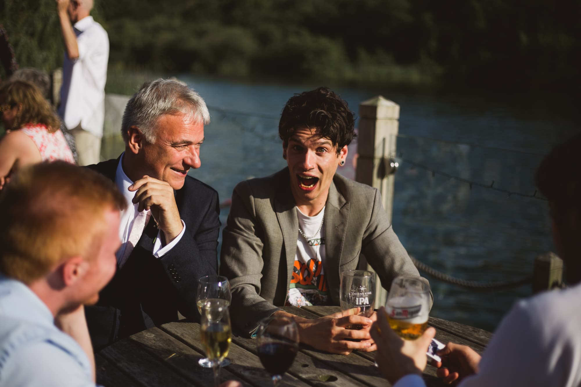 wedding guests drinking on the boathouse deck