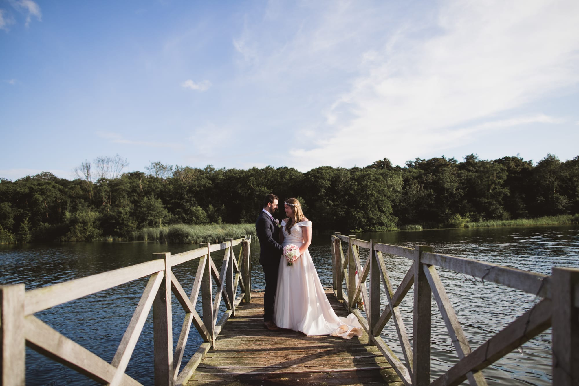 bride and groom on the jetty overlooking the norfolk broads