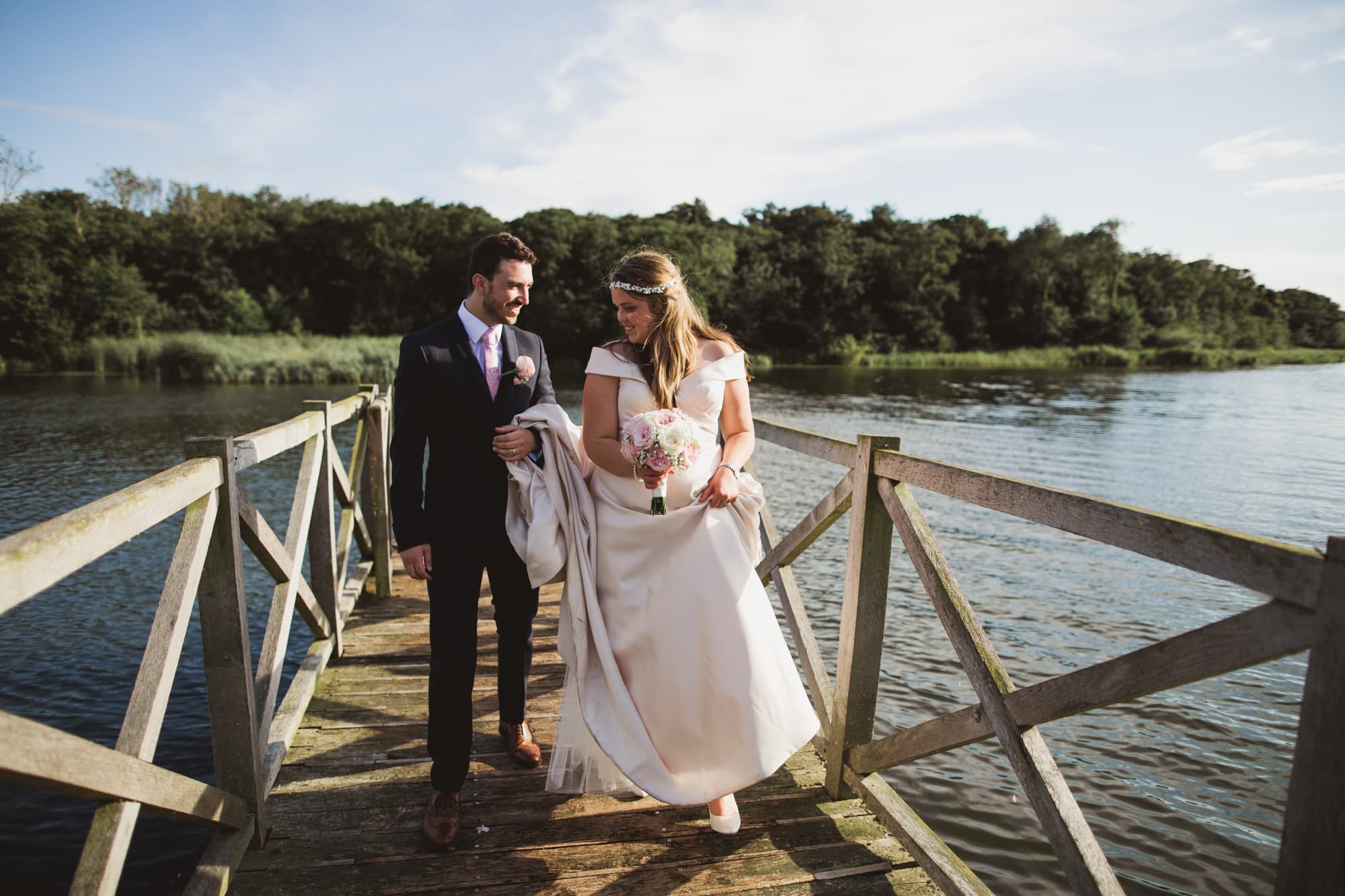 bride and groom on the jetty overlooking the norfolk broads
