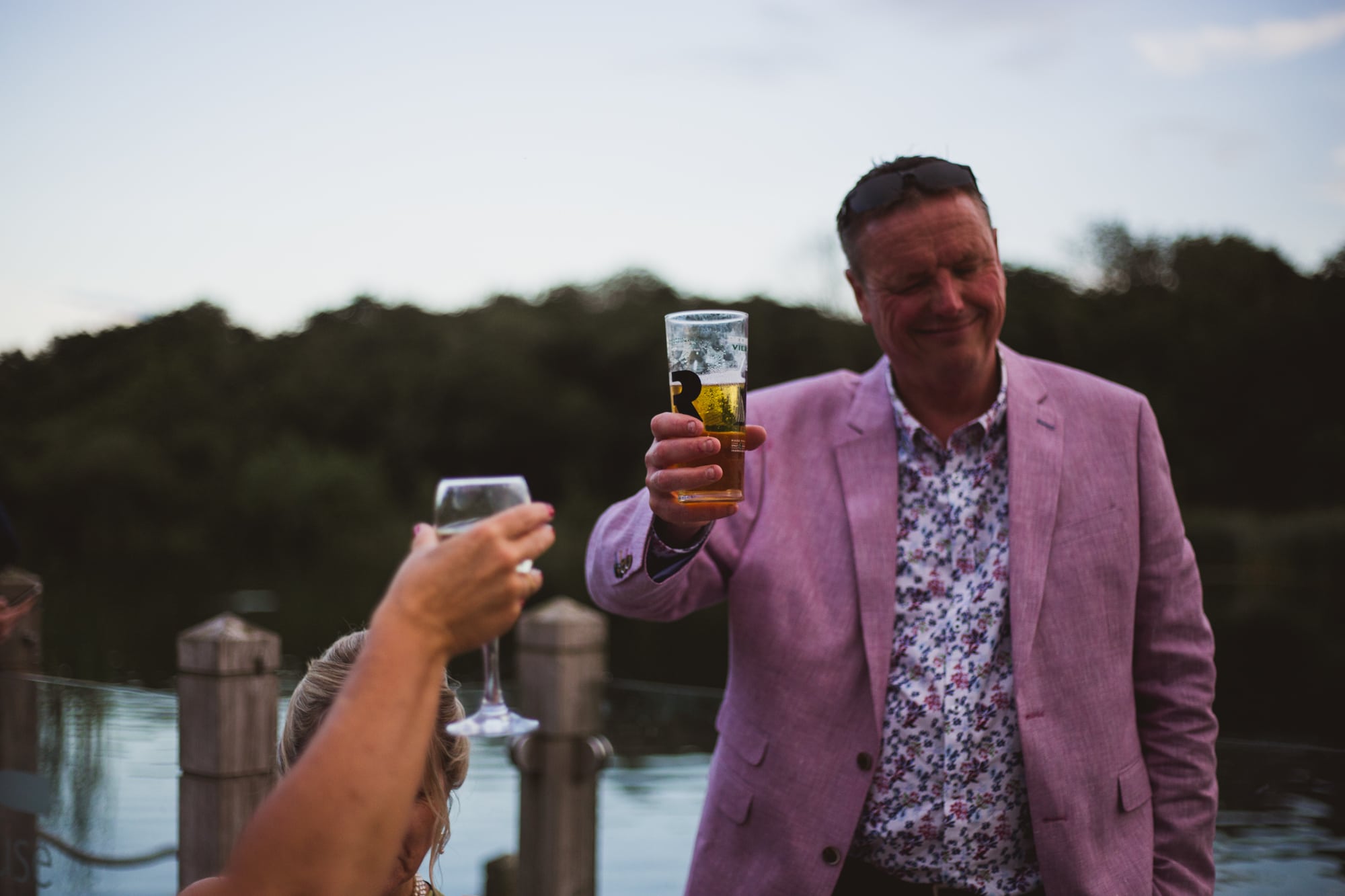 wedding guests enjoying drinks reception on the boathouse deck