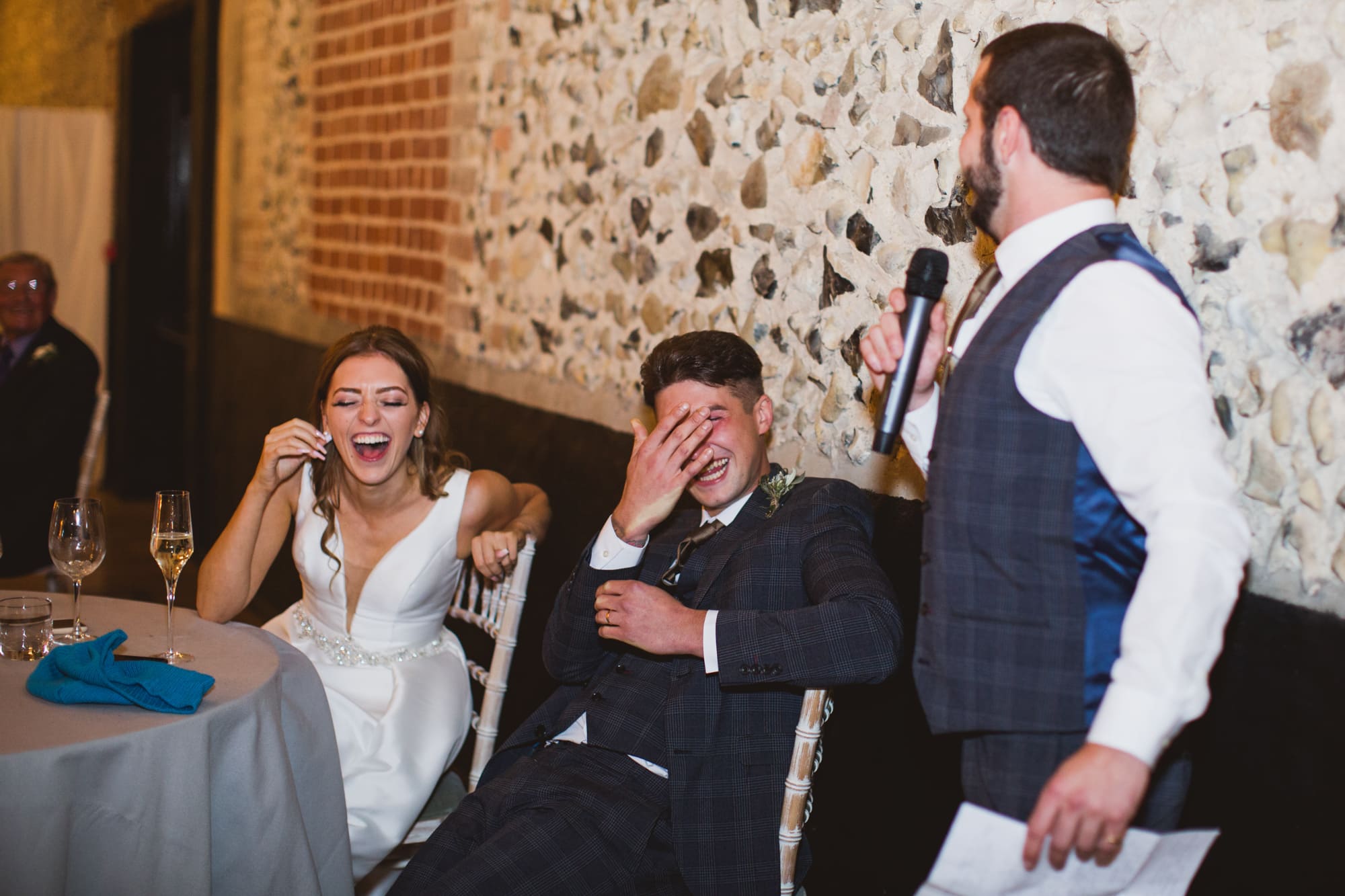 bride and groom laughing at bestmans speech