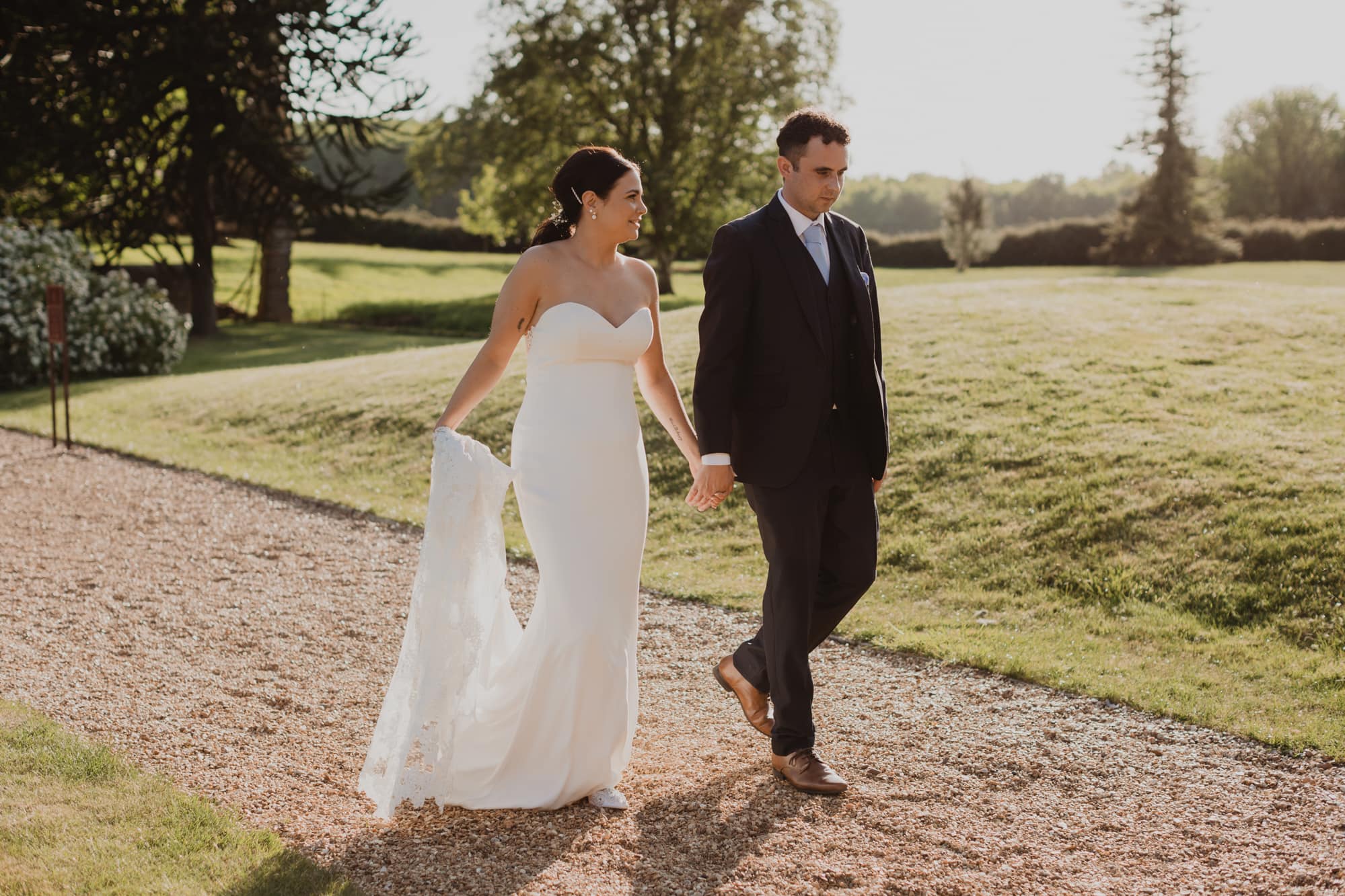 bride and groom walking hand in hand in the grounds at holmewood hall