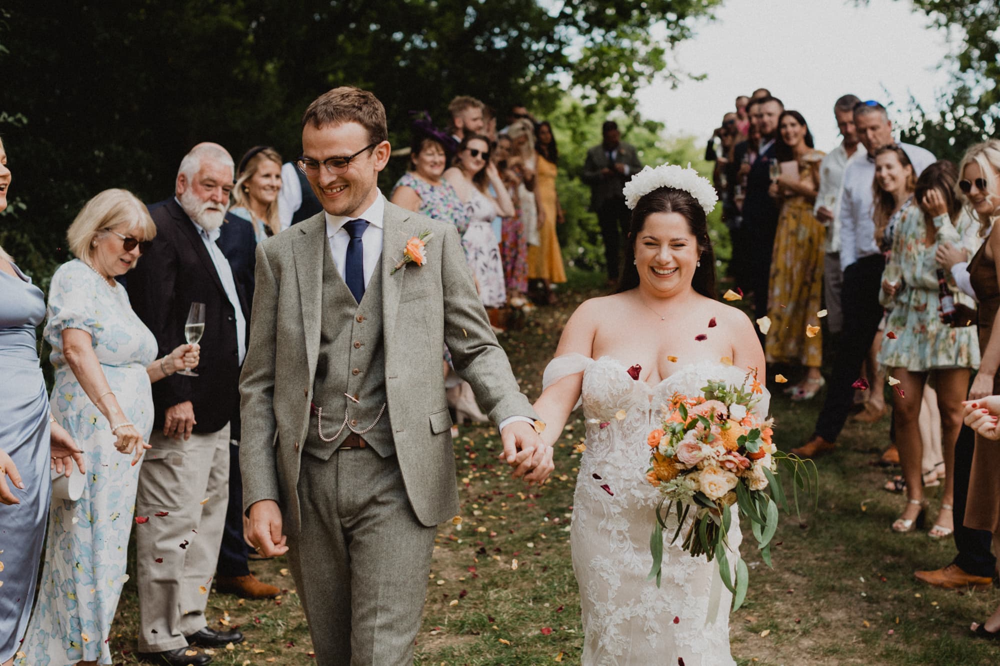 bride and groom walking through confetti at the dell little massingham barn