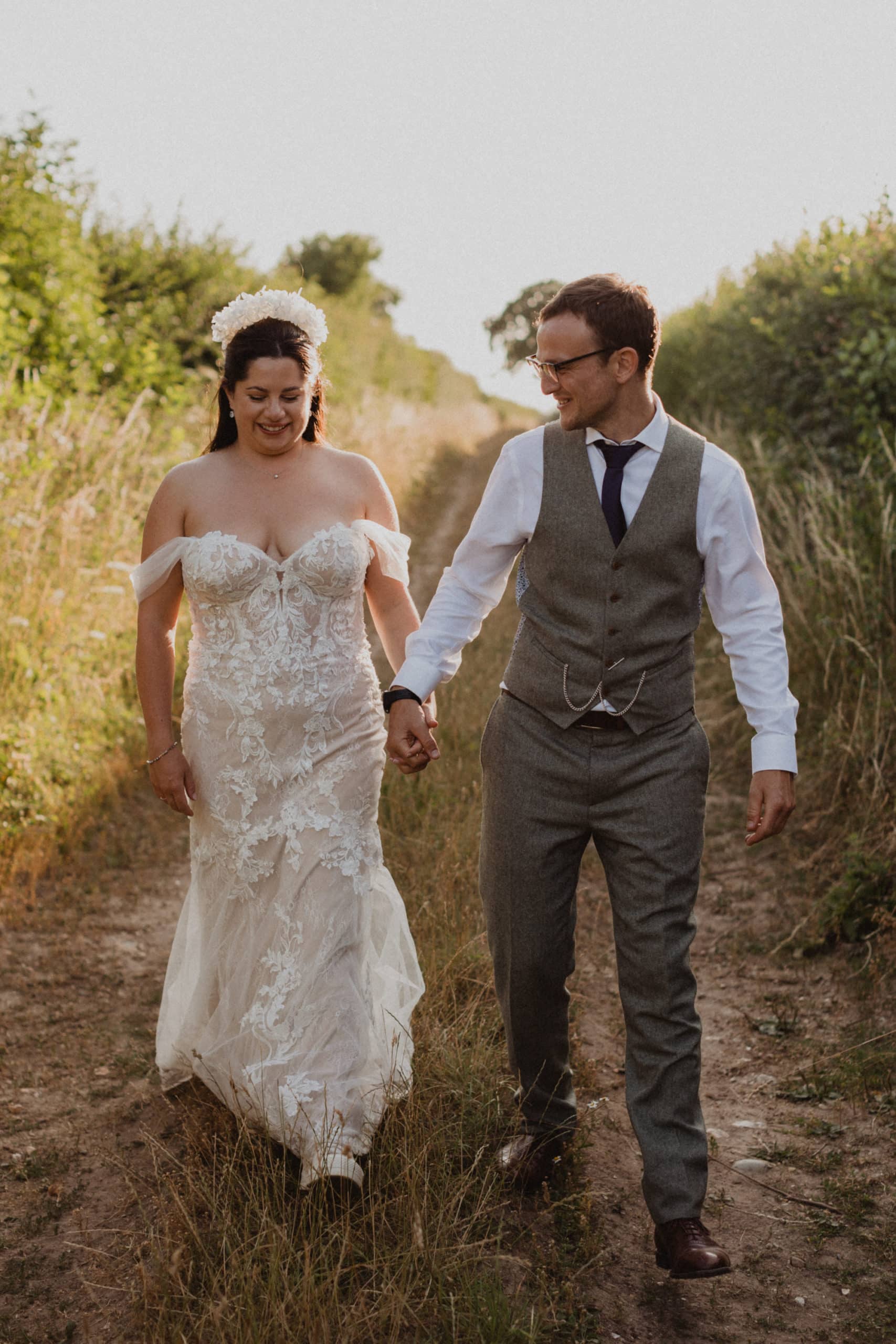 bride and groom walking hand in hand in a country lane for wedding photos