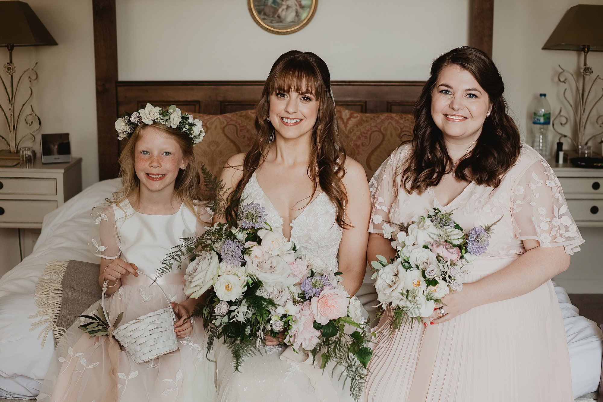 bride sitting with her bridesmaid and flower girl