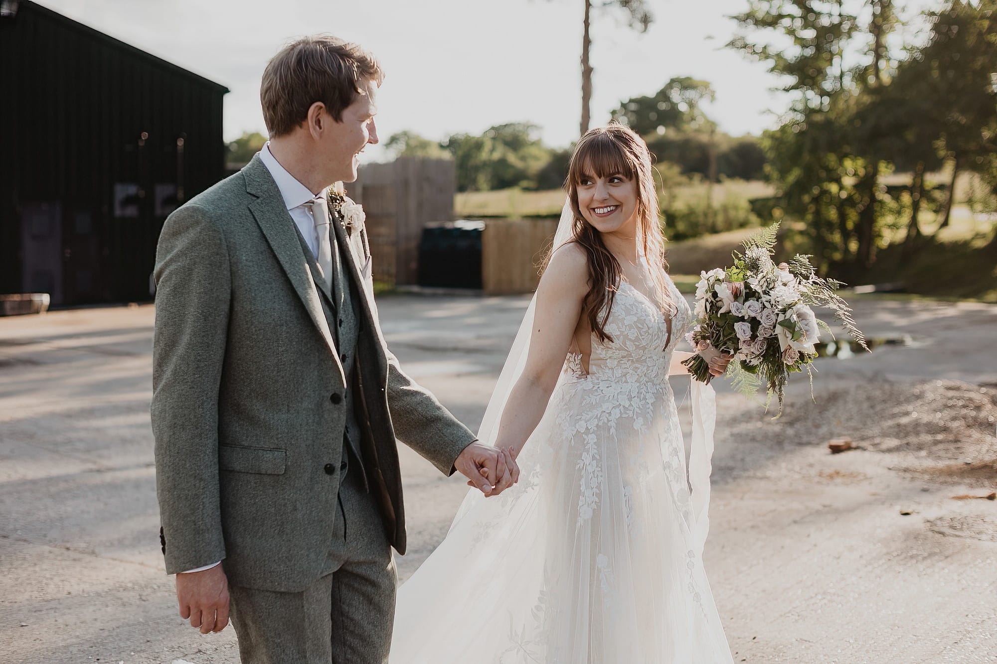 bride and groom walking hand in hand at bruisyard barn