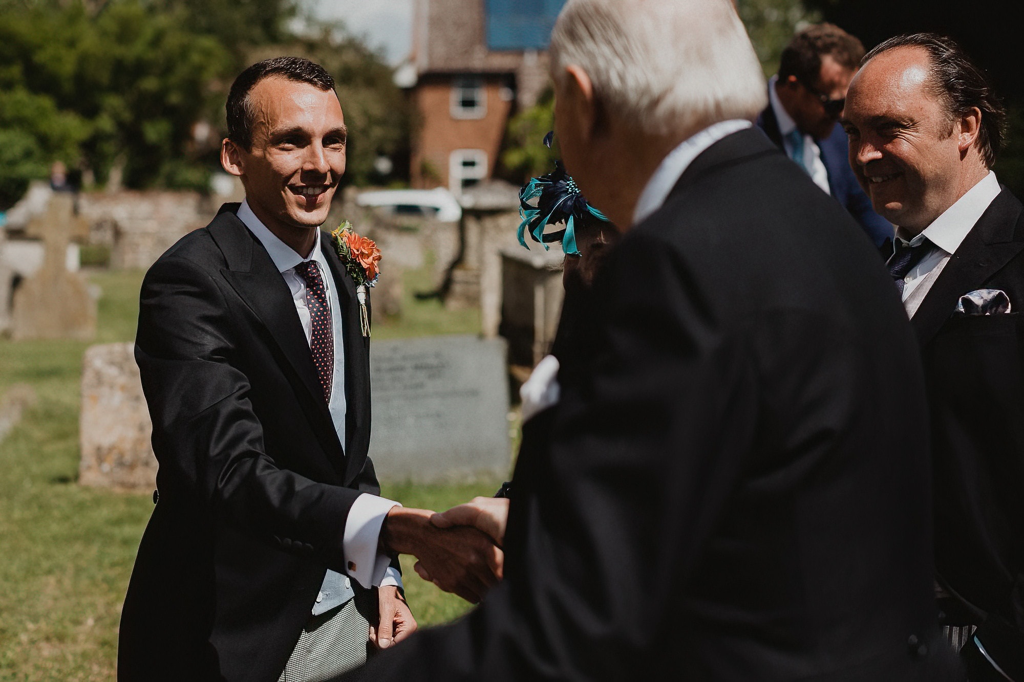 groom greeting guests at woolpit church suffolk