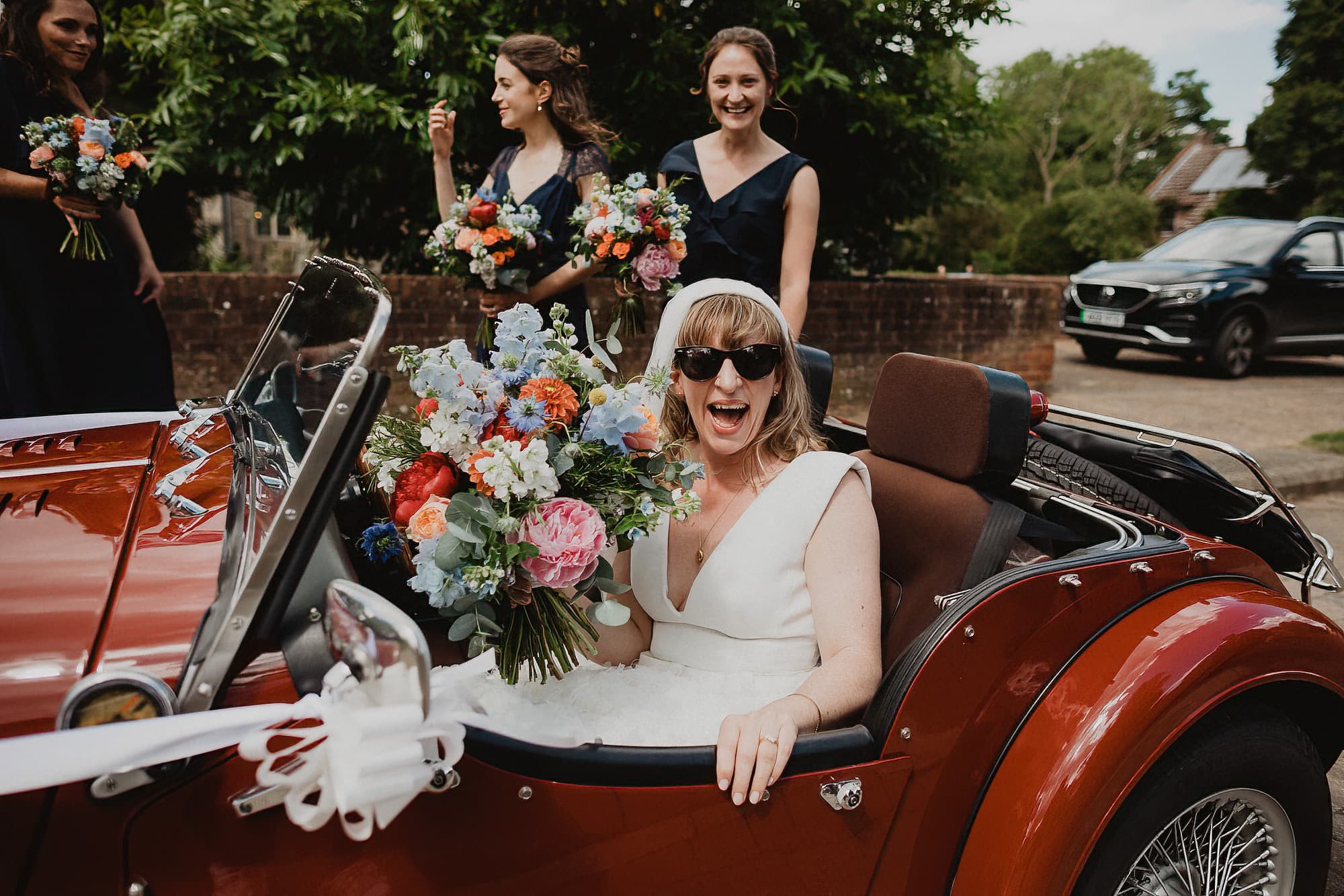 bride arriving at woolpit church in a morgan