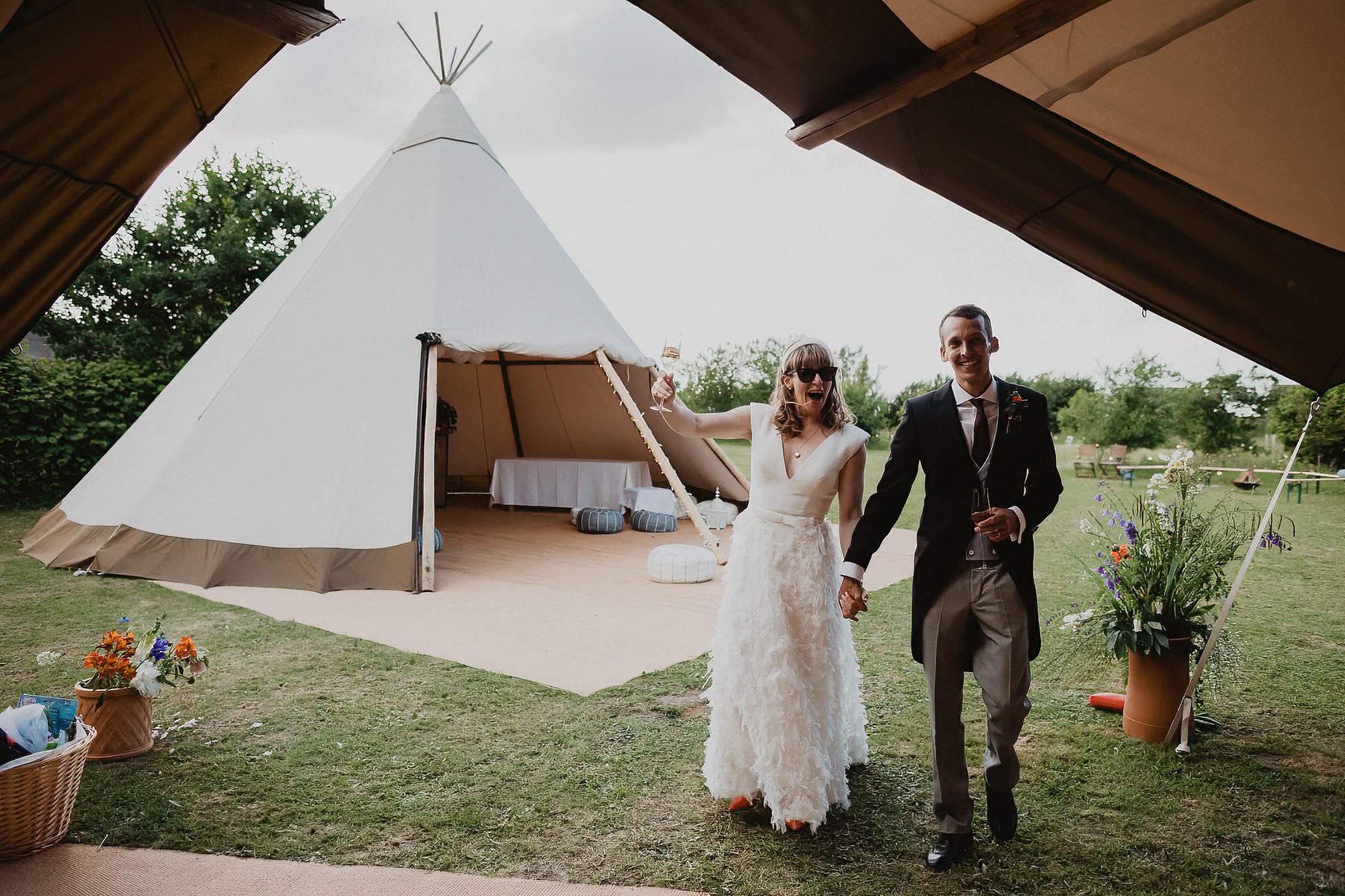 bride and groom being welcomed into their tipi wedding breakfast