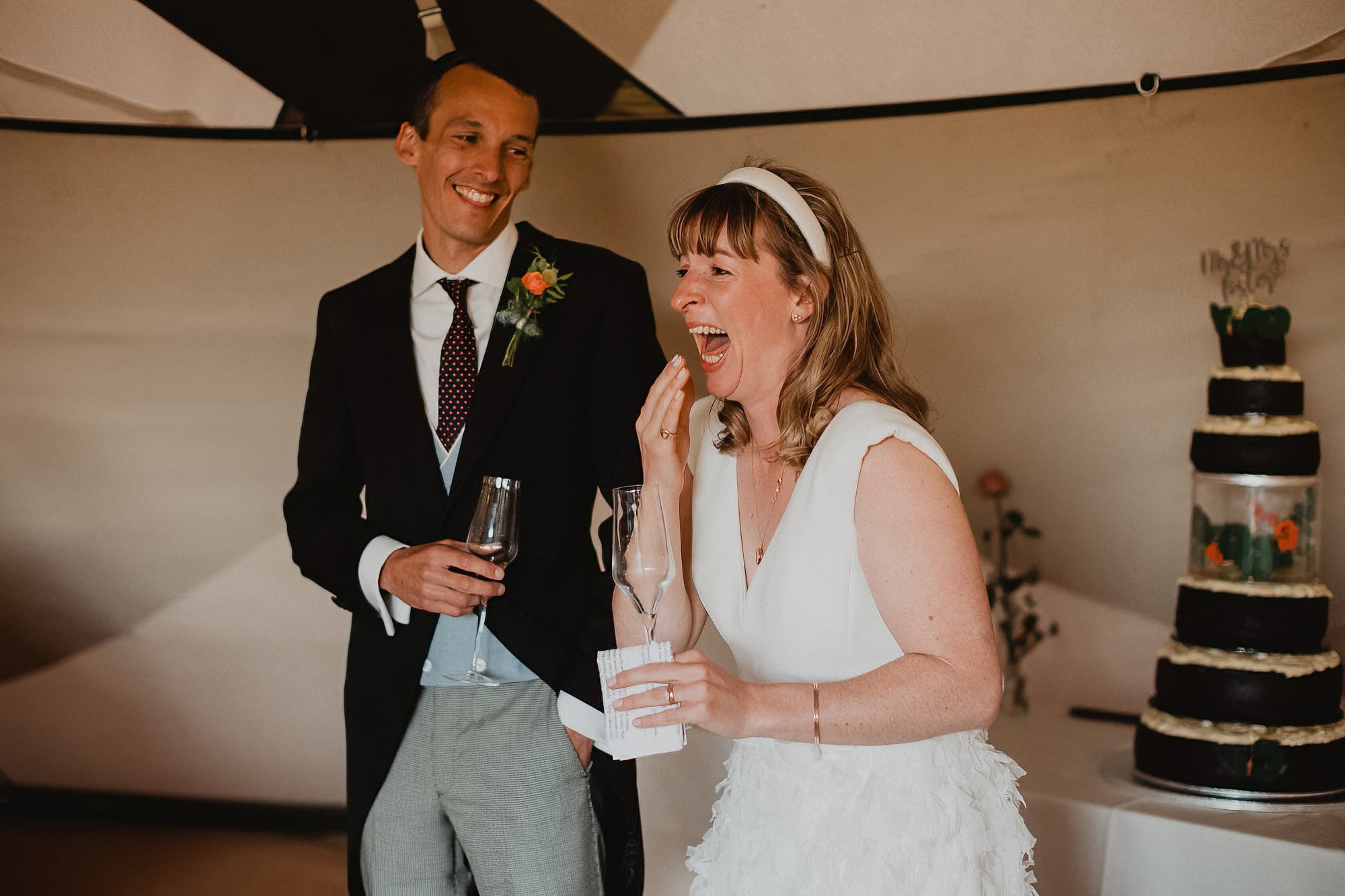 bride and groom laughing at wedding speeches
