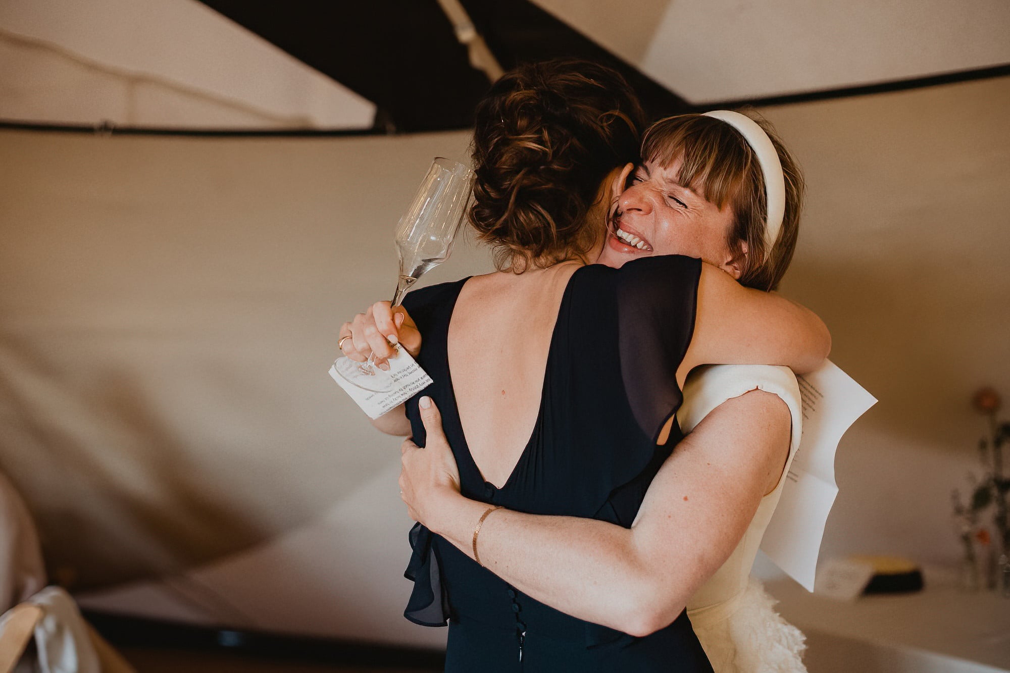 bride in embrace with best friend after speeches