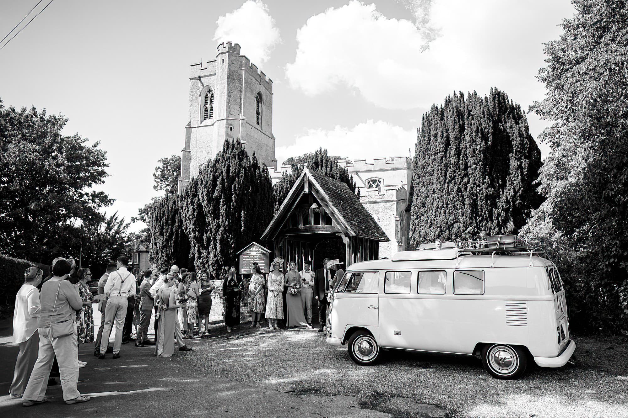 bride and groom leaving church in campervan