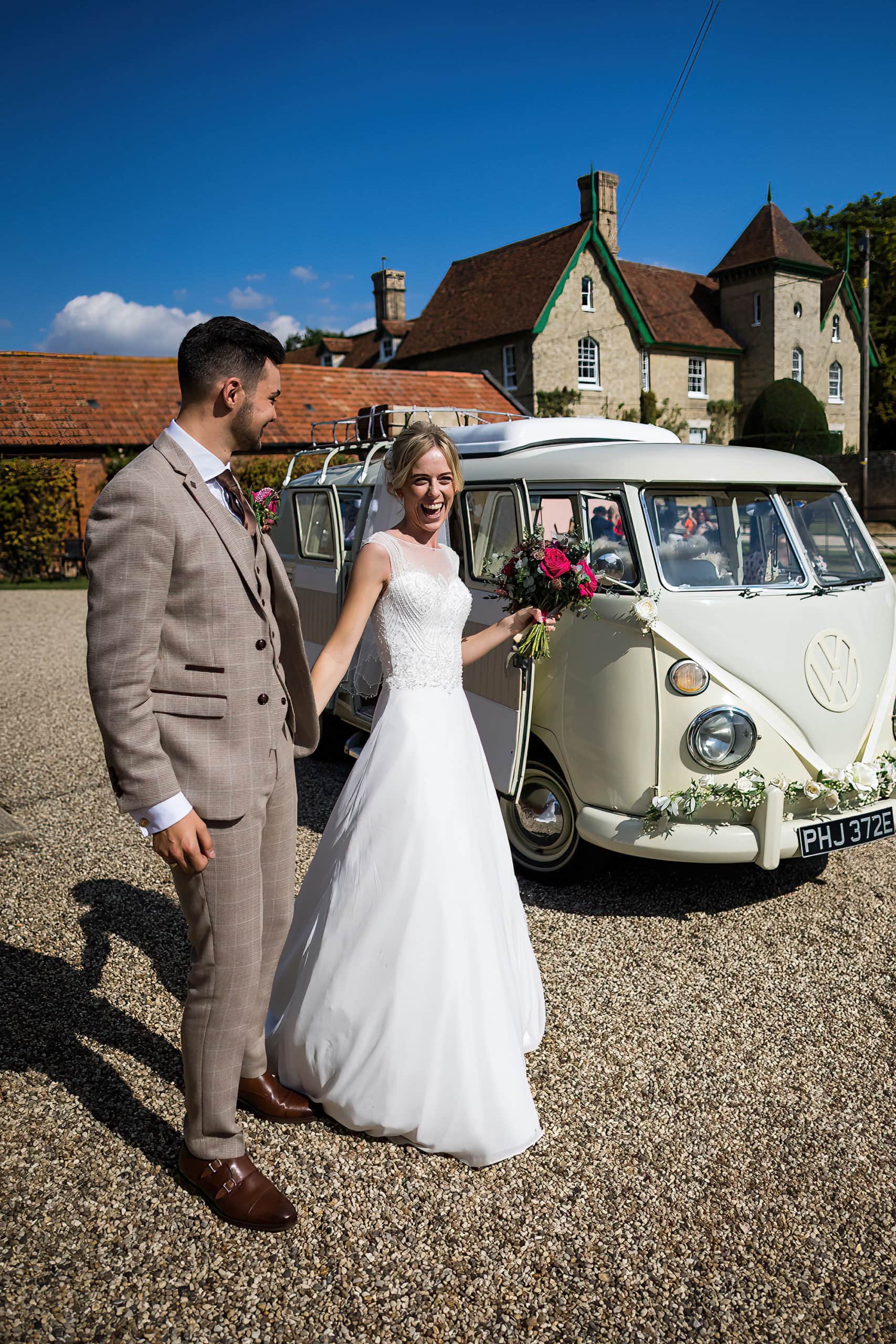 bride and groom arriving at their reception in campervan