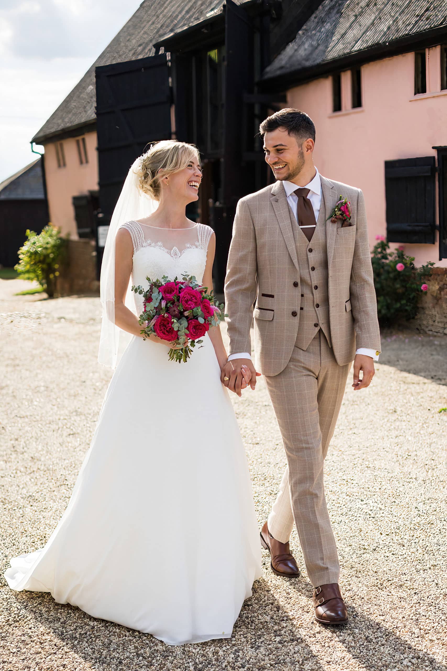 bride and groom walking hand in hand at smeetham hall barn