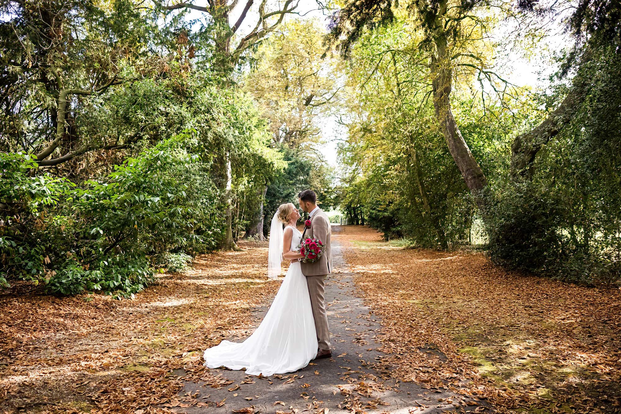 bride and groom portrait with trees in a lane at smeetham hall barn