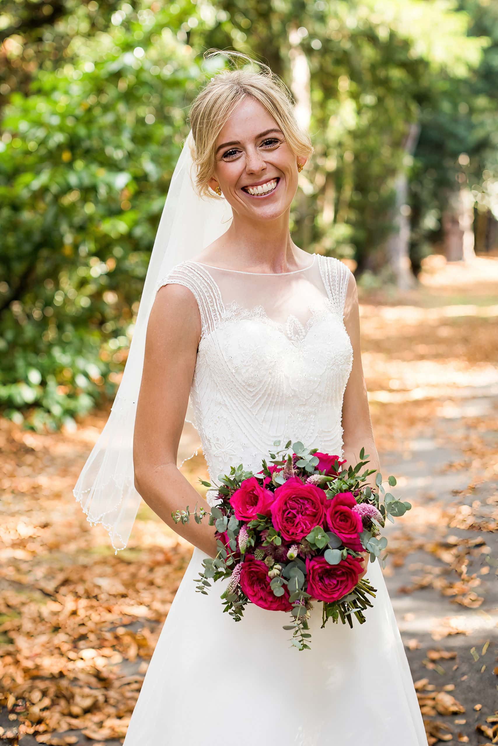 bride portrait in wedding dress with red rose bouquet