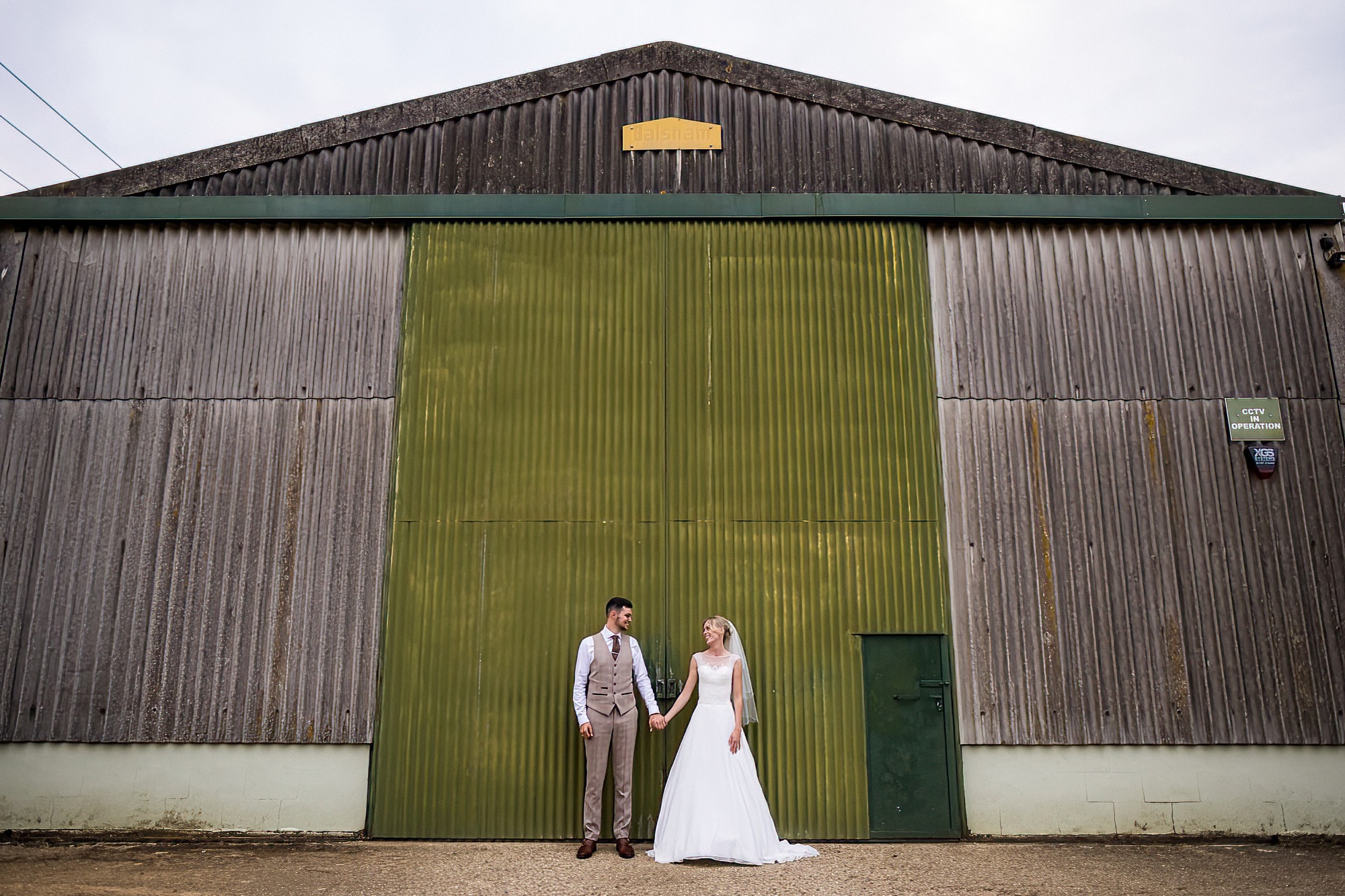 bride and groom wedding portraits in front of barn at smeetham hall barn