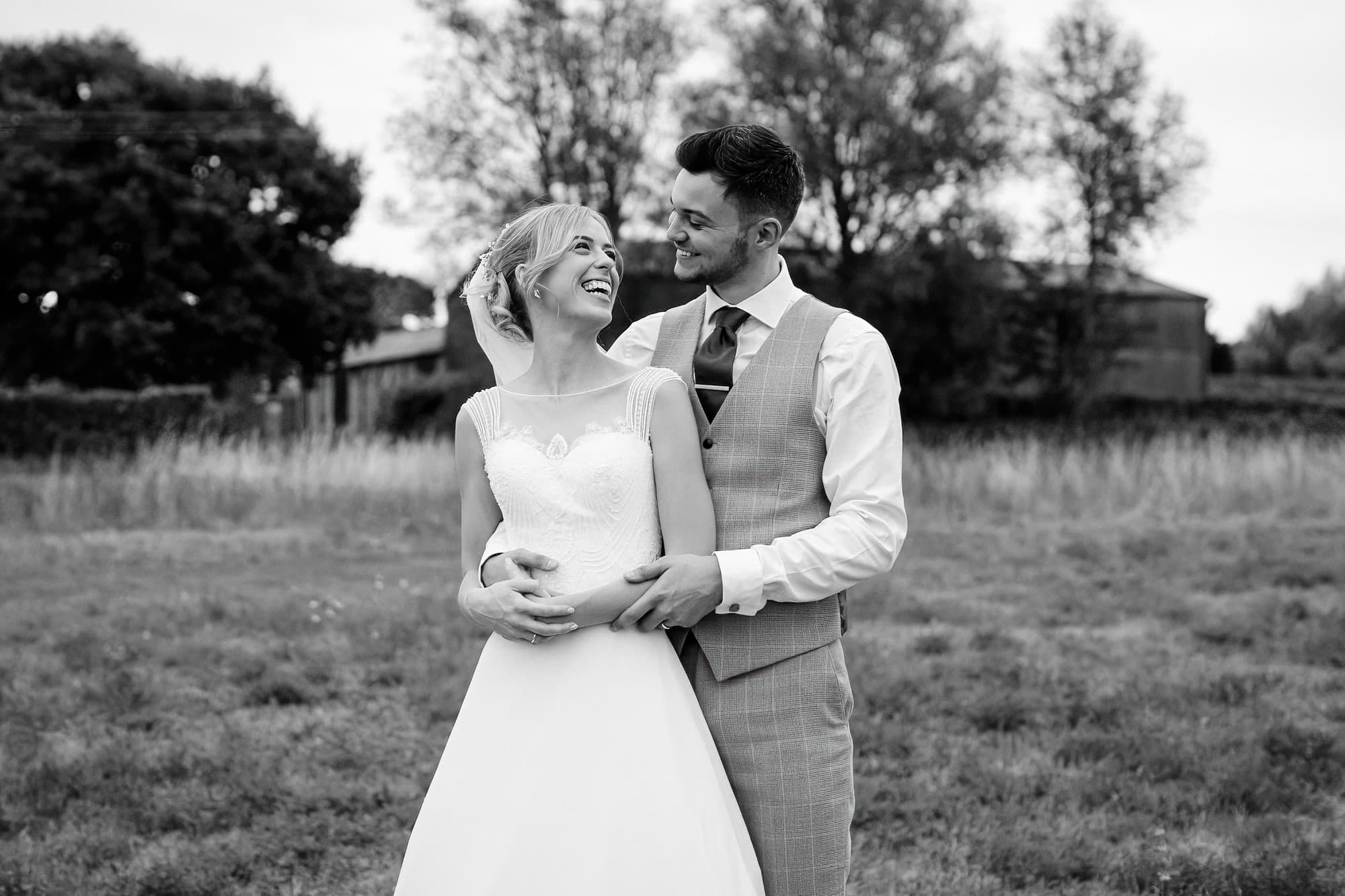 bride and groom wedding portraits in a field at smeetham hall barn