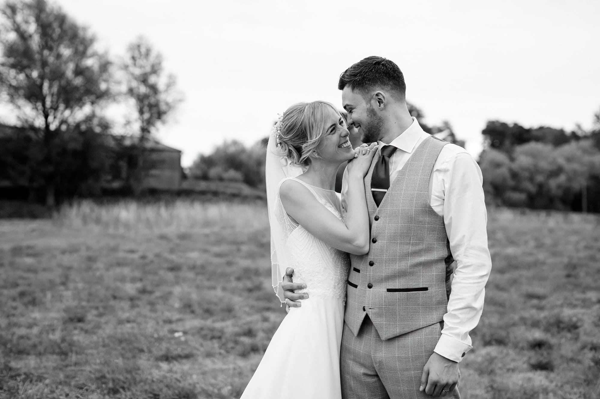 bride and groom wedding portraits in a field at smeetham hall barn
