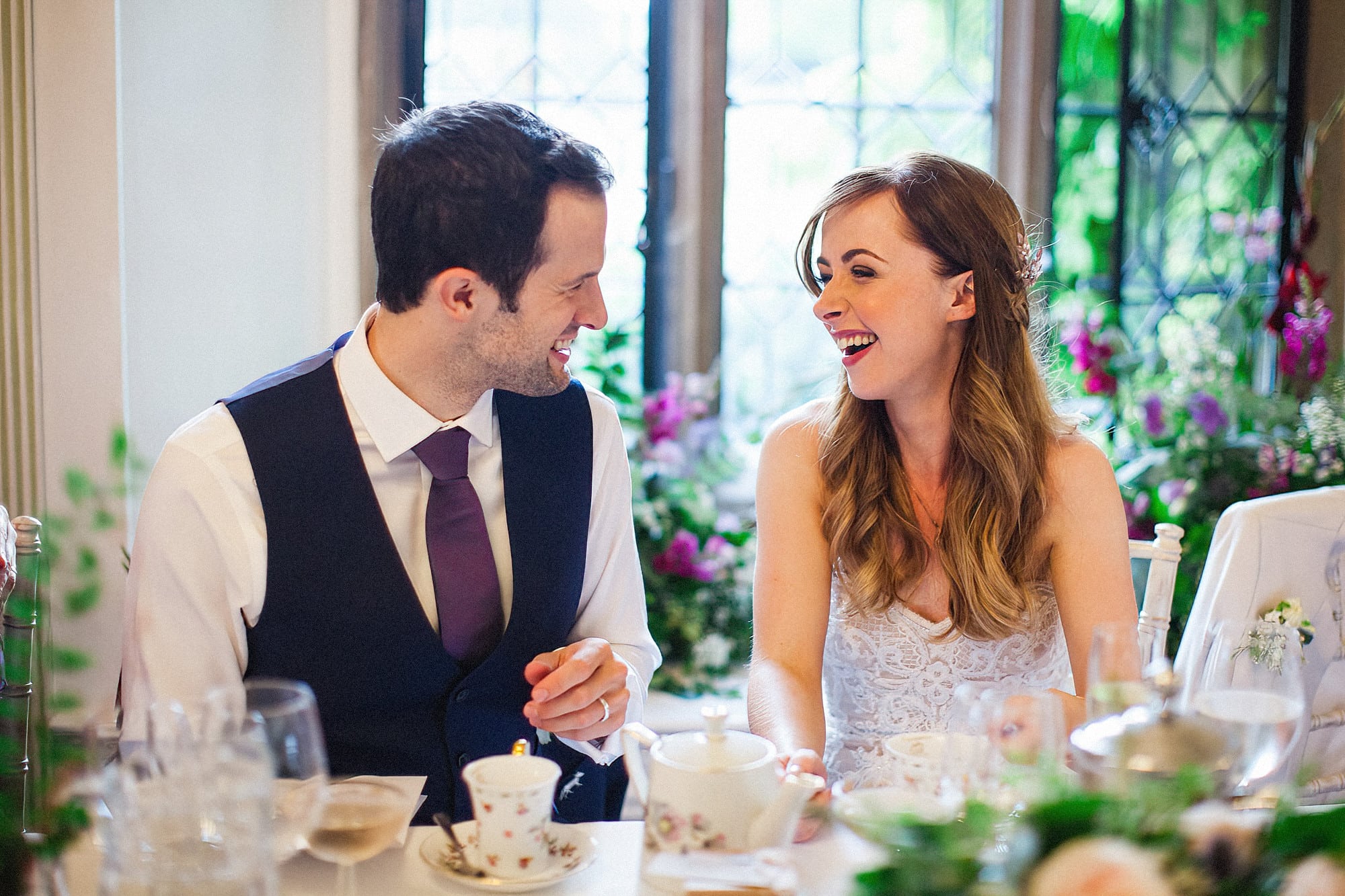 bride and groom laughing at wedding breakfast at hengrave hall