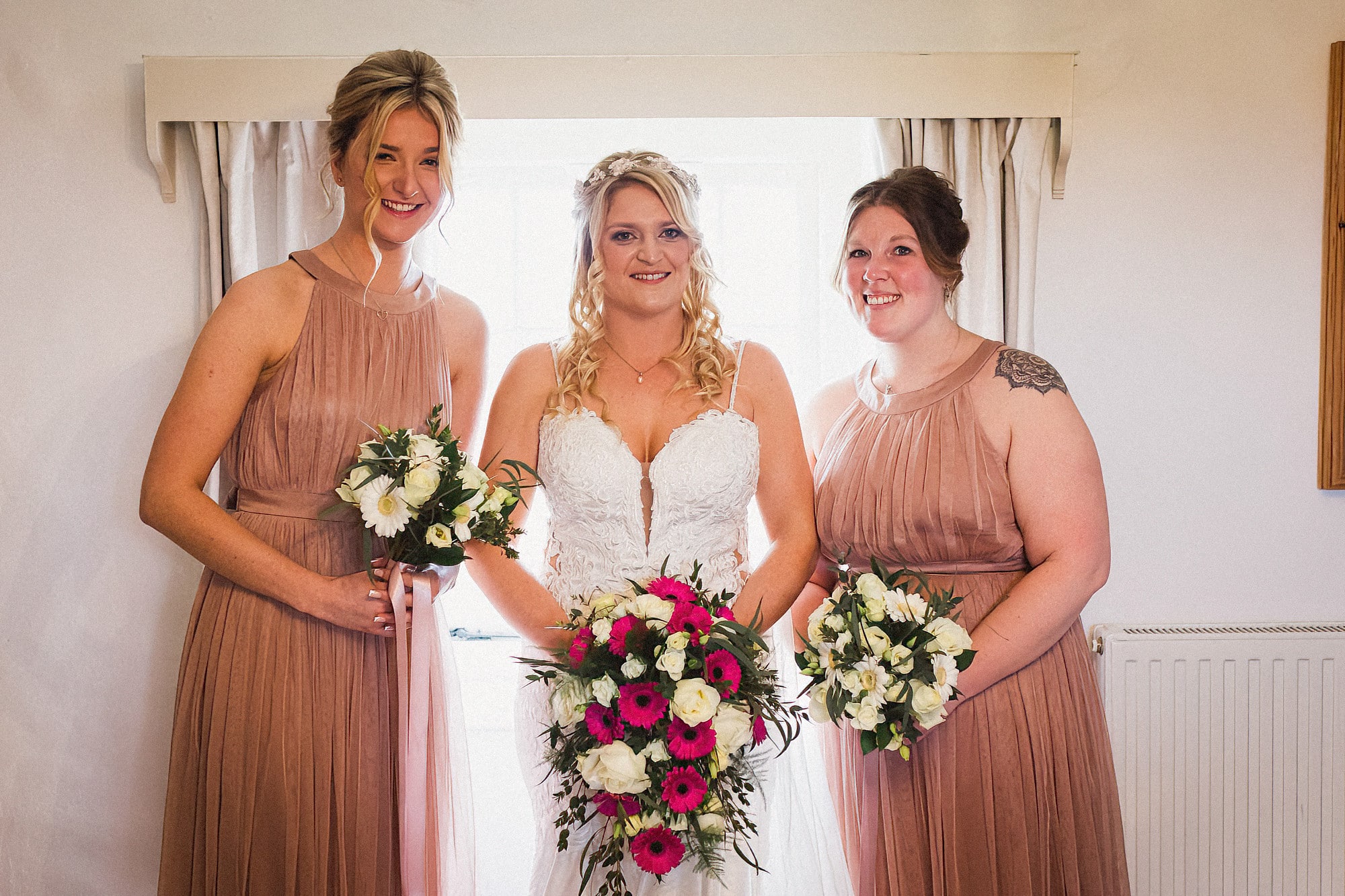 bride and bridemaids in pink dresses and holding their bouquets