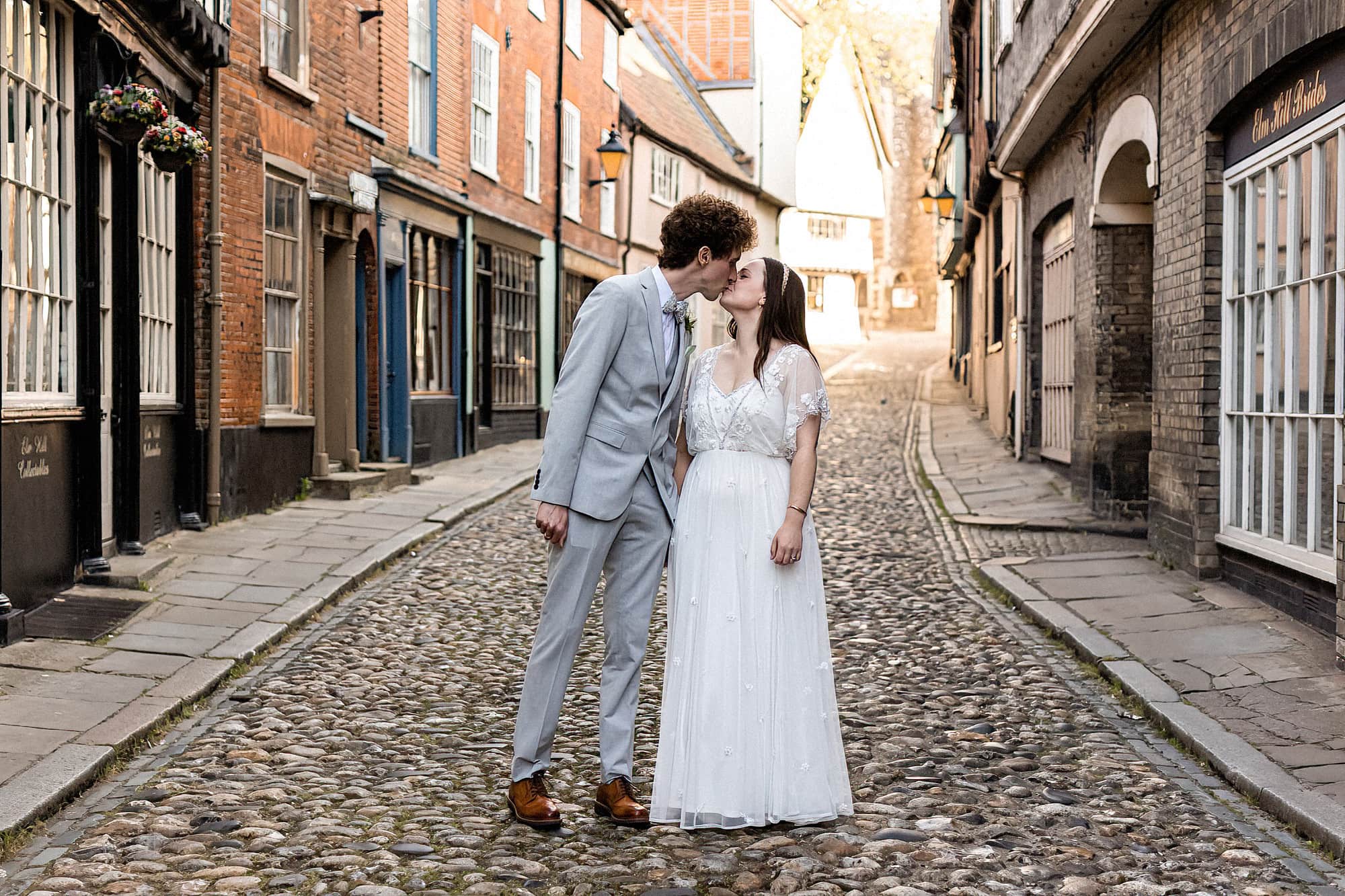 bride and groom kissing for photo on elm hill norwich