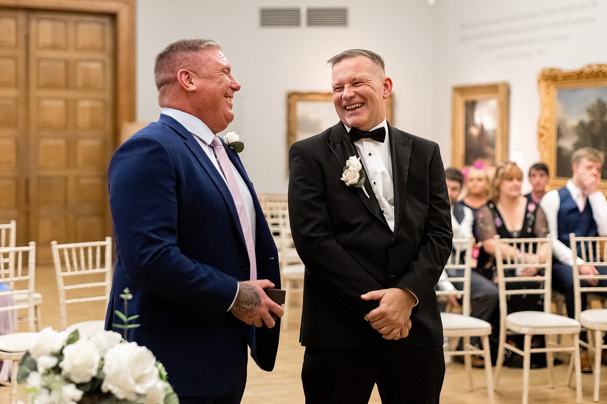 groom with best man waiting for bride laughing