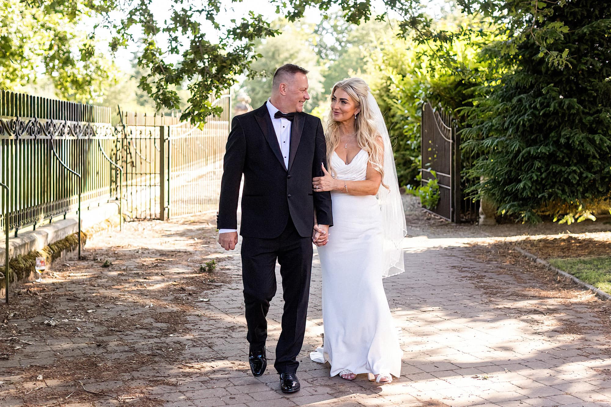 bride and groom walking arm in arm through garden at dunston hall