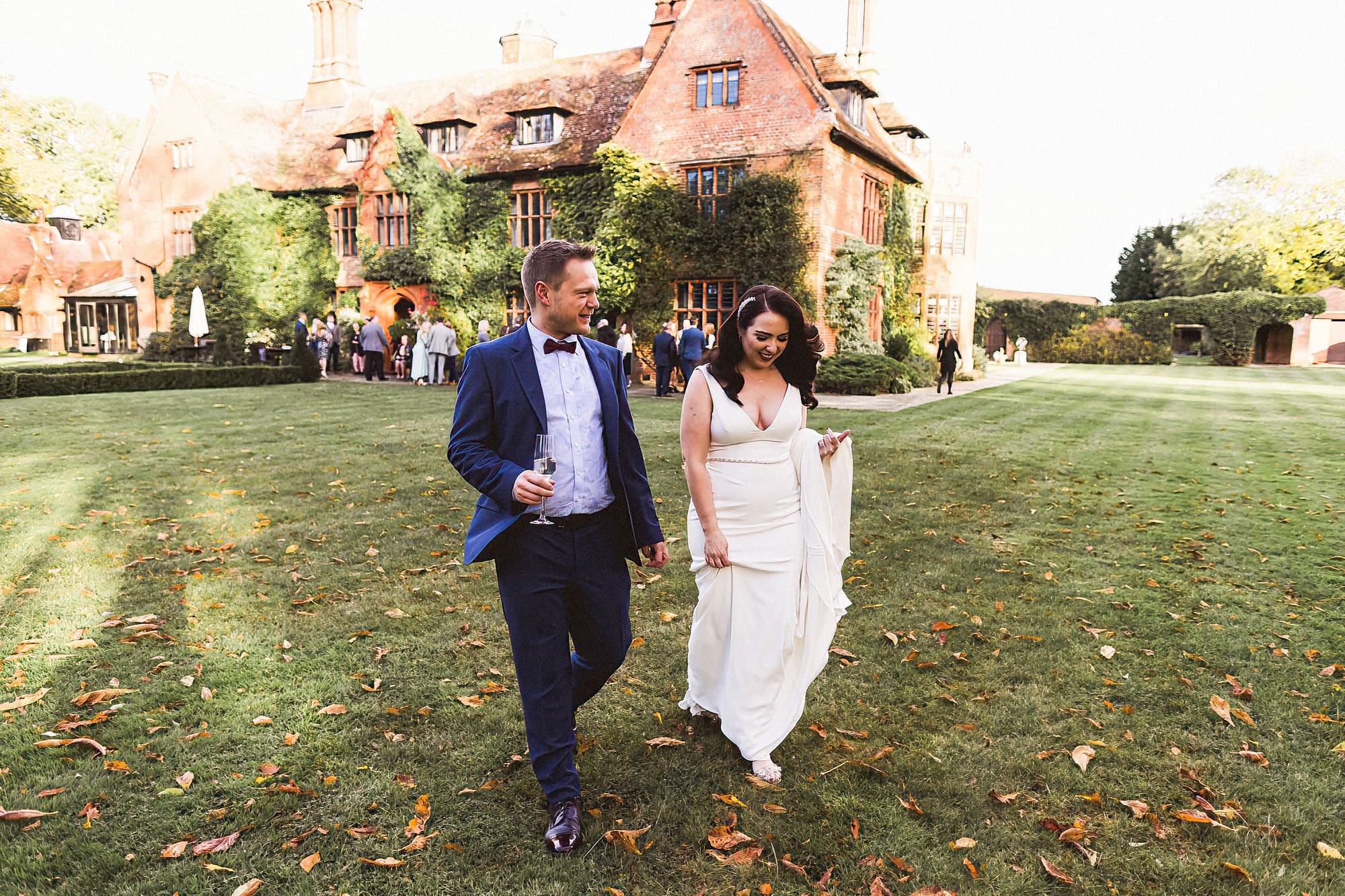 bride and groom walking across the gardens at woodhall manor